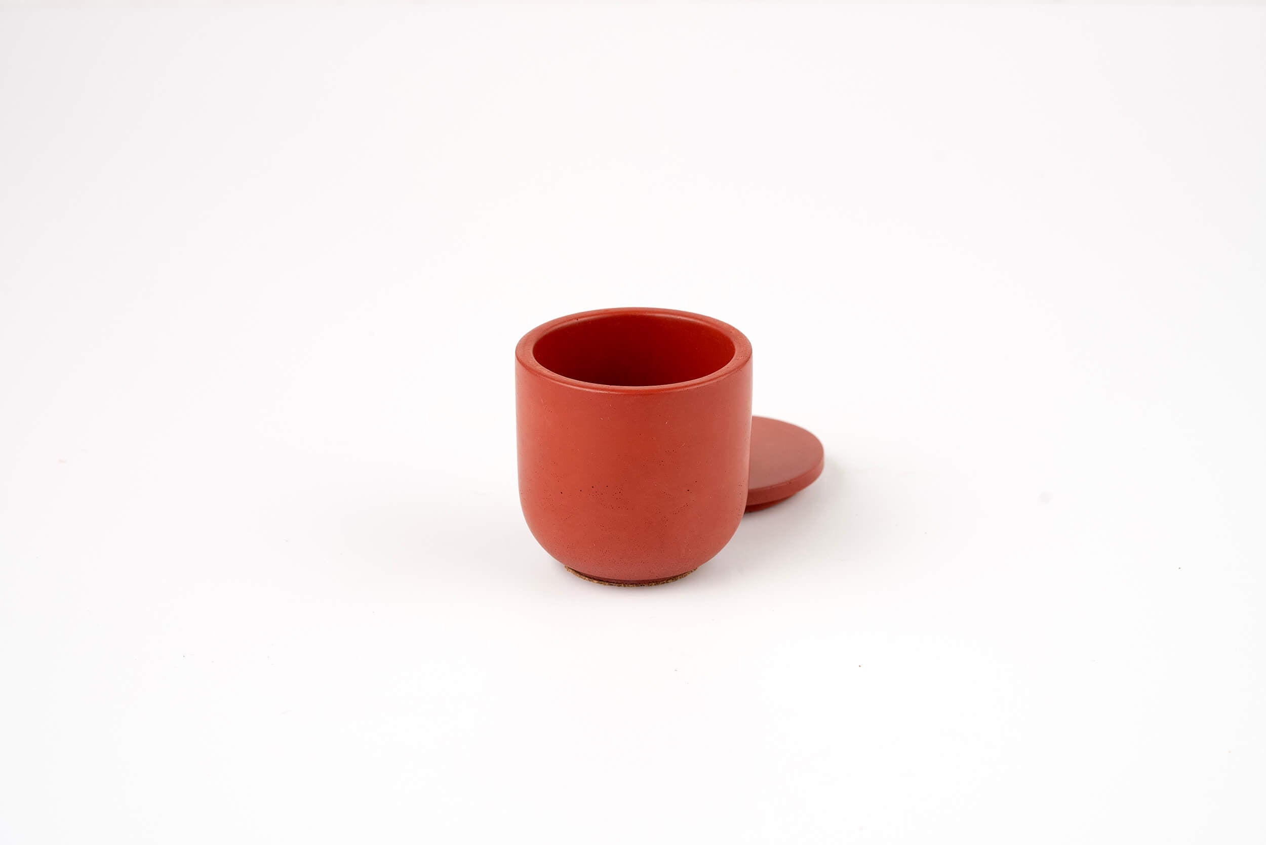The Lava Candle Vessel is a small, round, red scent refill container shown with a matching lid beside it on a plain white background.