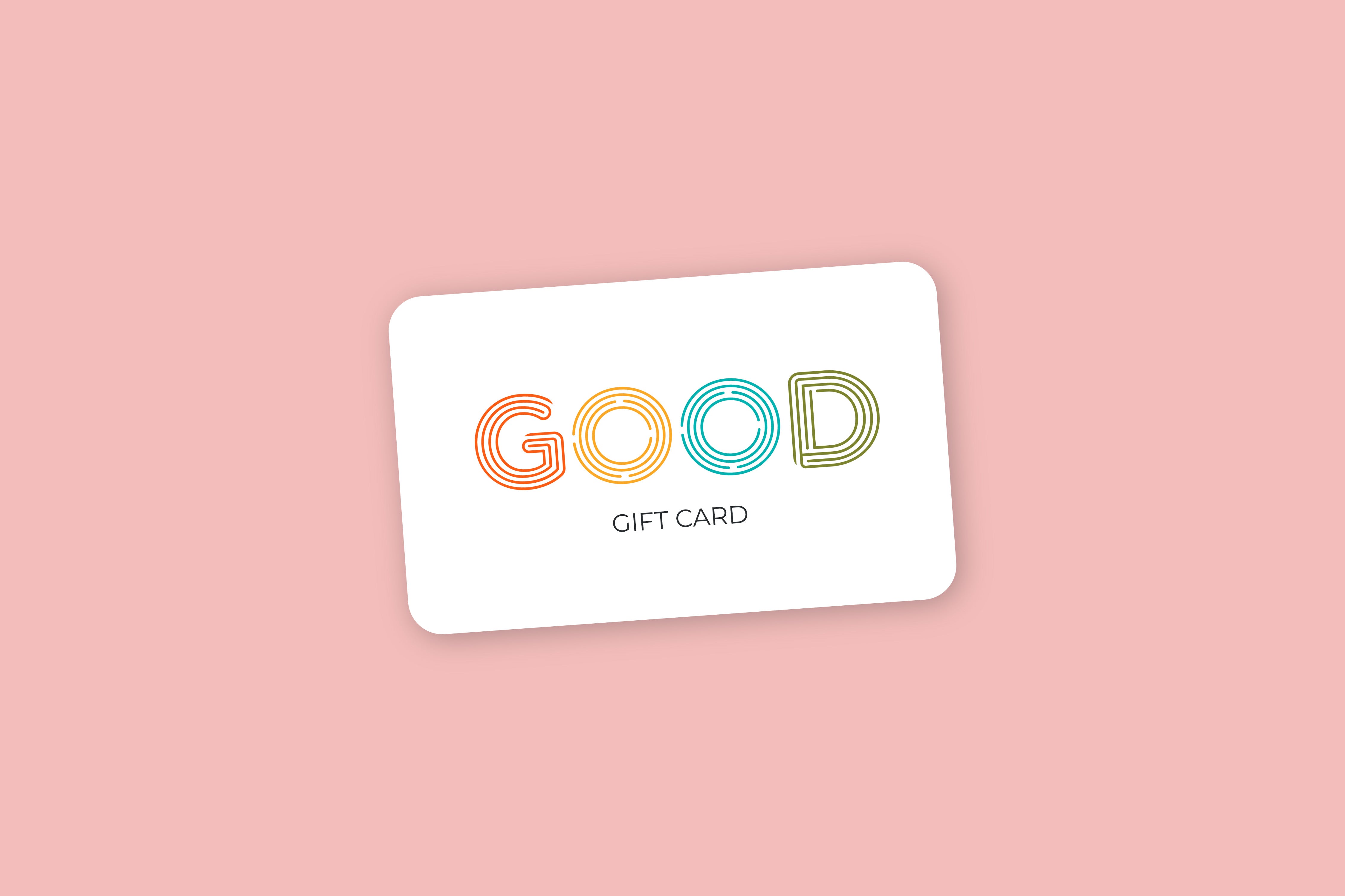 A white FFO Goods Gift Card from the brand FFO Goods is displayed on a pink background, featuring the word GOOD in vibrant, striped letters with GIFT CARD written below in black—an ideal gift for those who love luxurious soy wax candles.