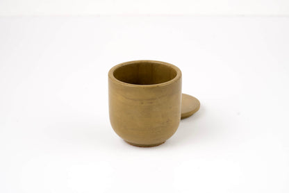 The Bark Candle Vessel is a small, round, brown clay vessel with a matching flat lid placed behind it on a white background—ideal for holding your favorite candle scent refill.