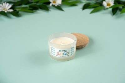 The Mint Meadow candle features a refreshing scent in a refillable concrete vessel, offering sustainable elegance. Surrounded by white daisies and leaves, this candle is perfect for bringing fresh vibes to your space.