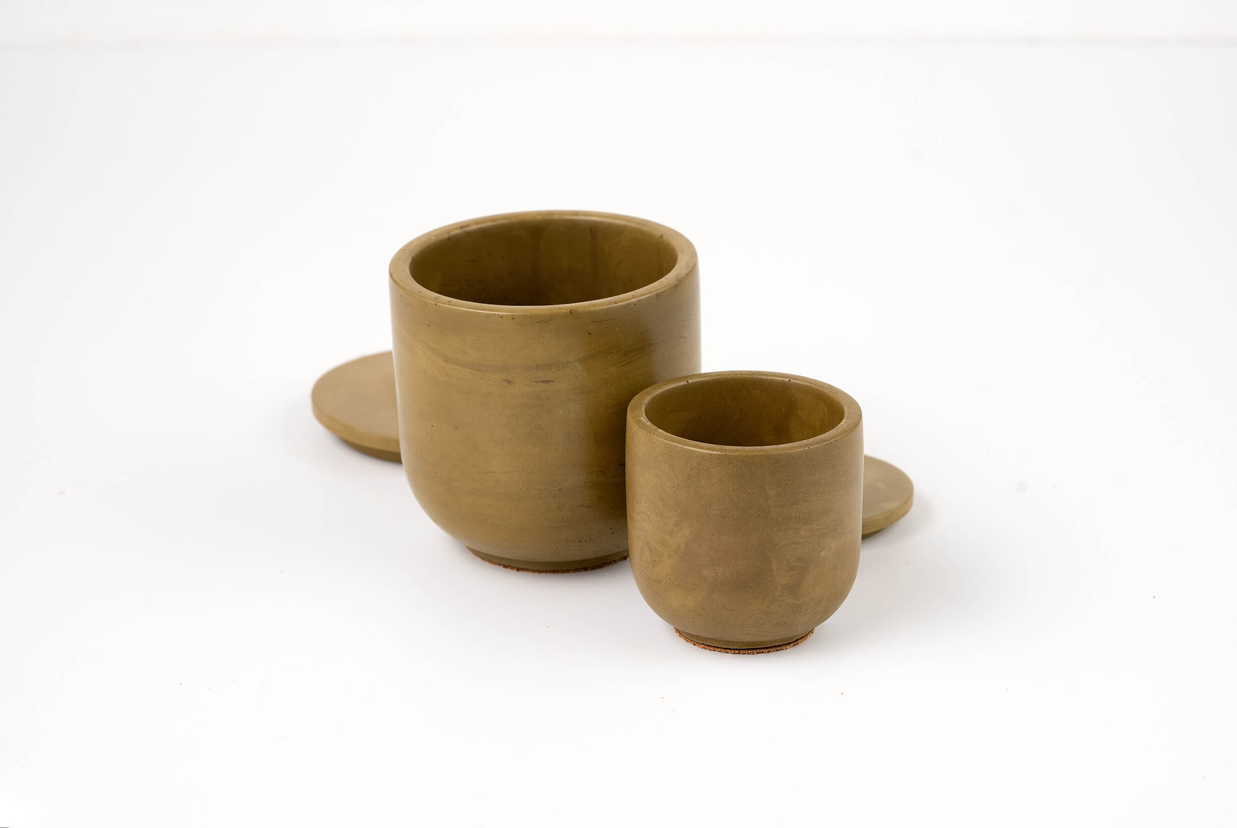 Two unglazed brown Bark Candle Vessels in different sizes sit side by side on a white surface, each with a matching lid behind them. Perfect for refilling with your favorite candle scent.